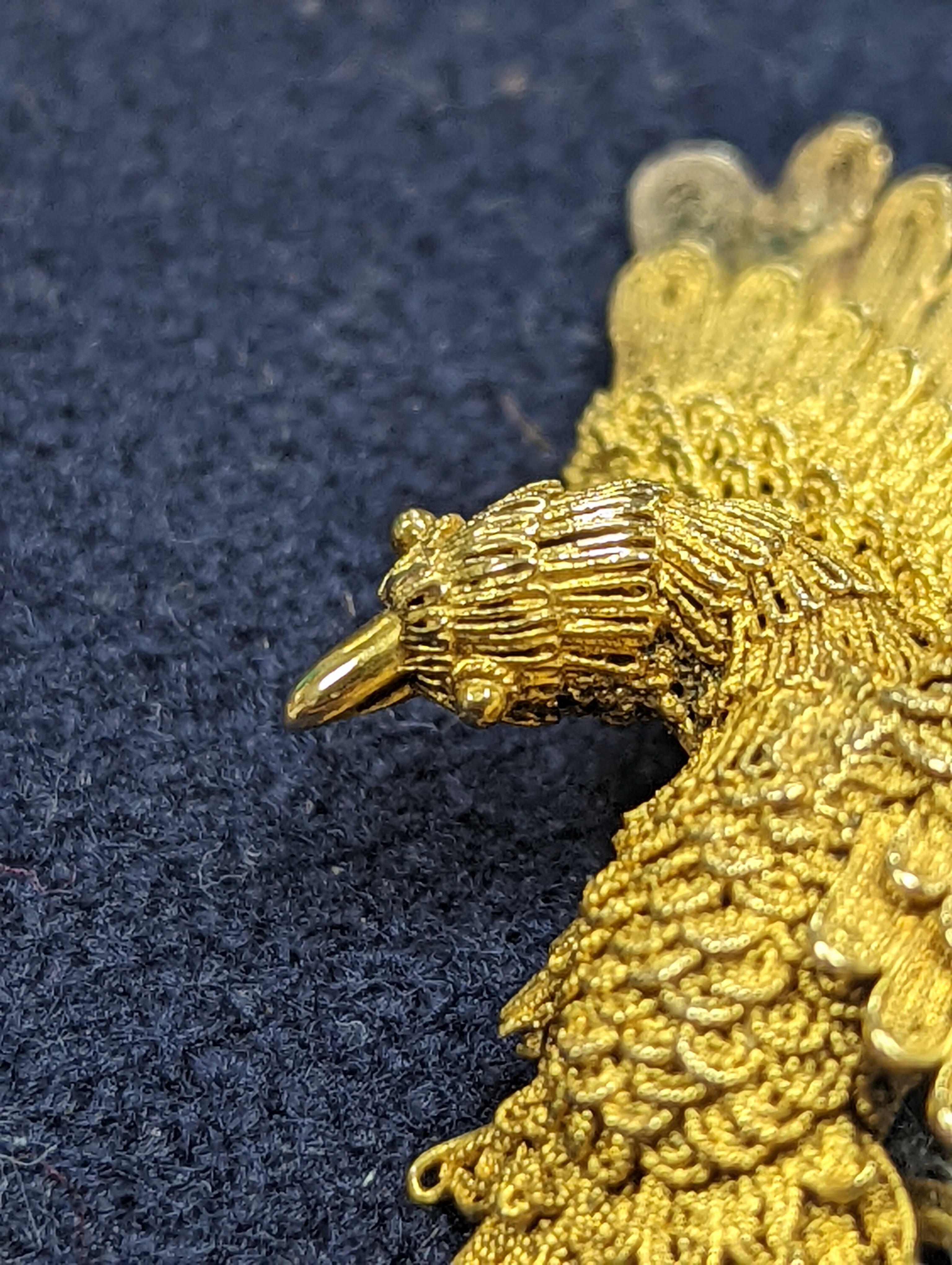A Chinese filigree yellow metal eagle brooch, stamped 'WS 20 (with character marks)', 36mm, gross 6.5 grams.